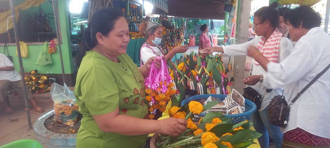 Women buying flowers at Wat Kham Chanot